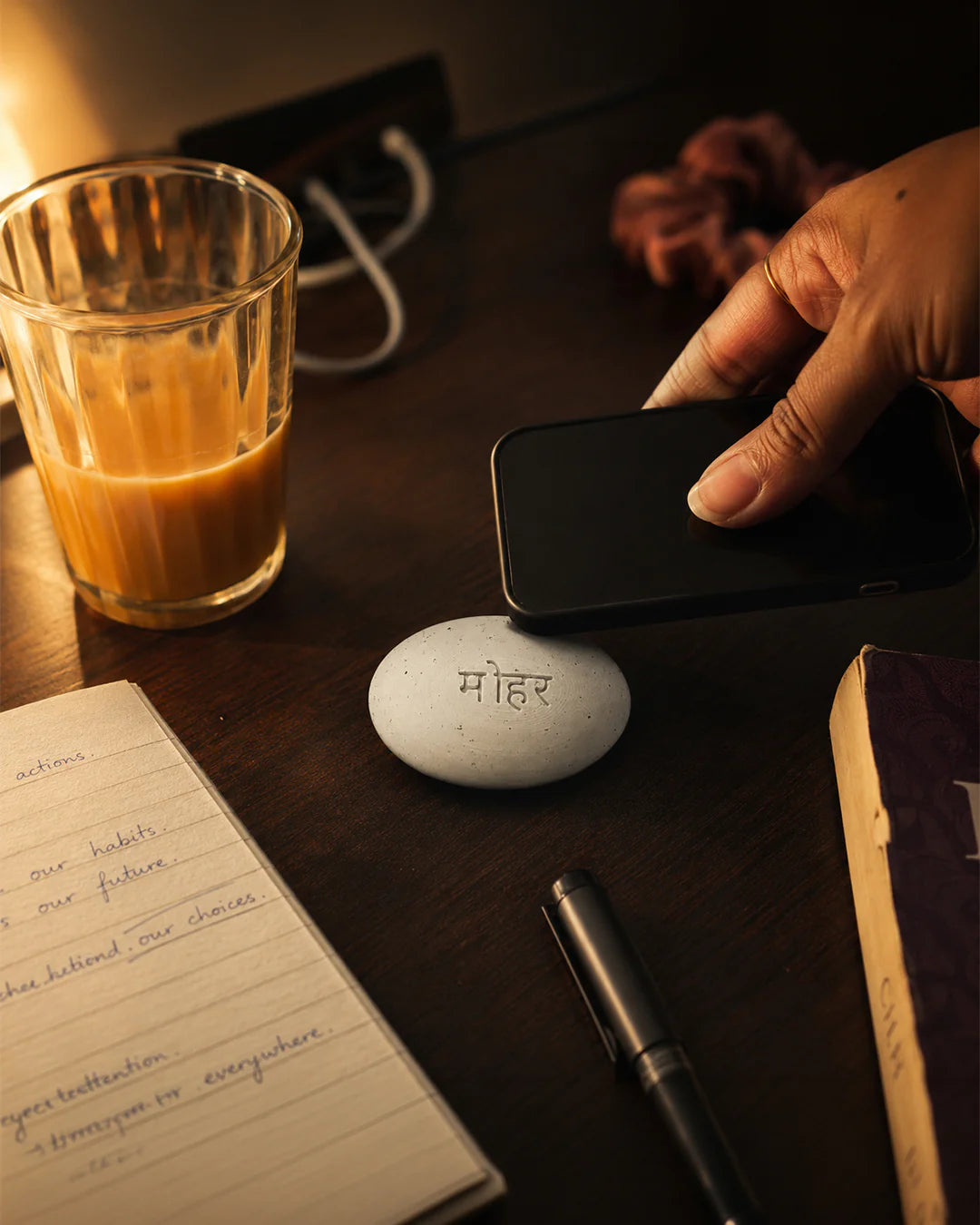Hand tapping phone to Mohar tile on desk